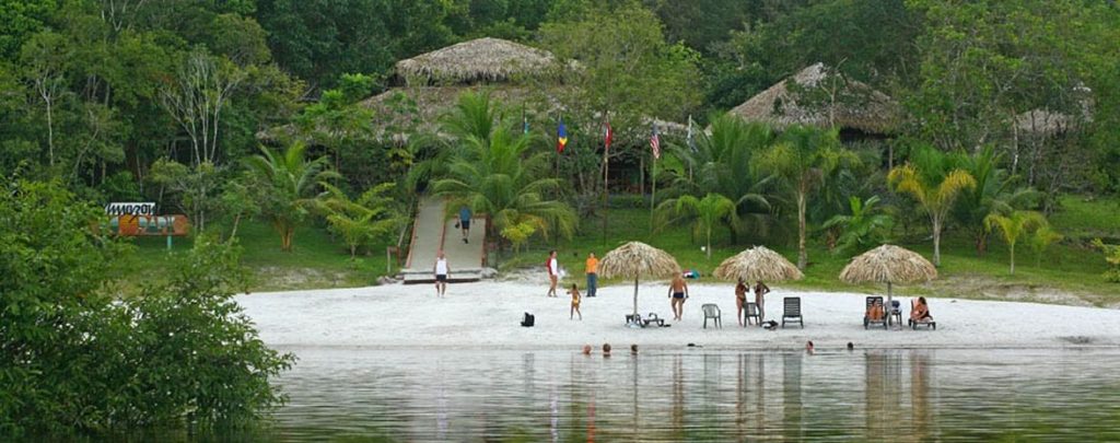 A shot of the Amazon eco-park, people enjoying the beach on the edge of the lake. 