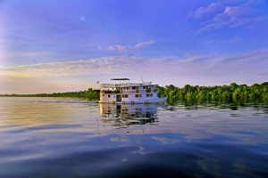 A boat moves along the river on an Amazon river cruise. 