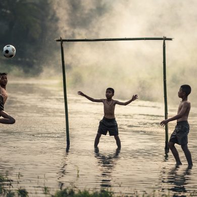 Kids play football in the mud in Brazil.