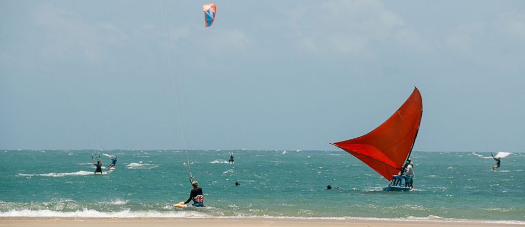 Kitesurfers in the sea along with the jangadas.