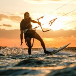 Kitesurfer learns to ride in the sunset.