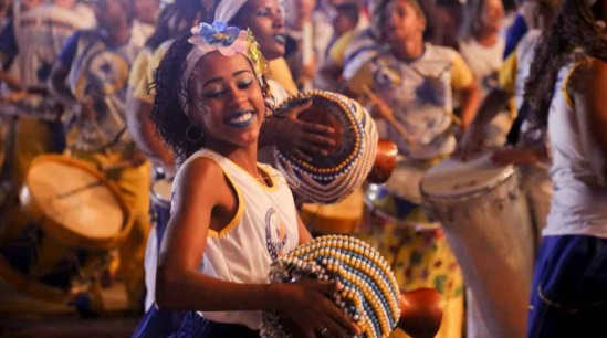 A woman plays a drum during the night of the silent drums in Recife.